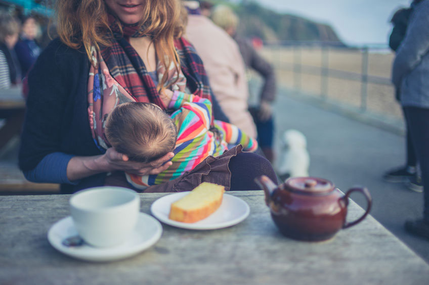 Mother breastfeeding at a cafe