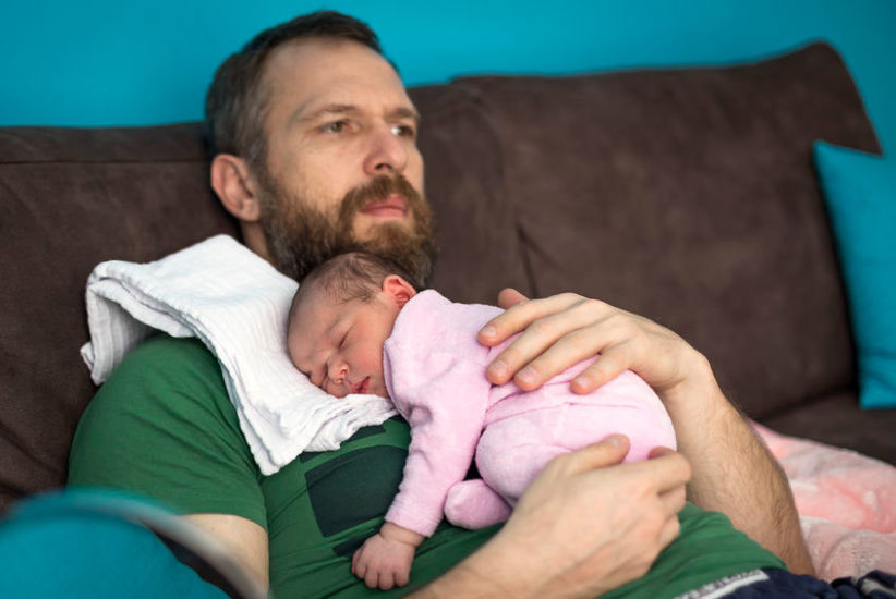 baby with reflux sleeps on his father's chest