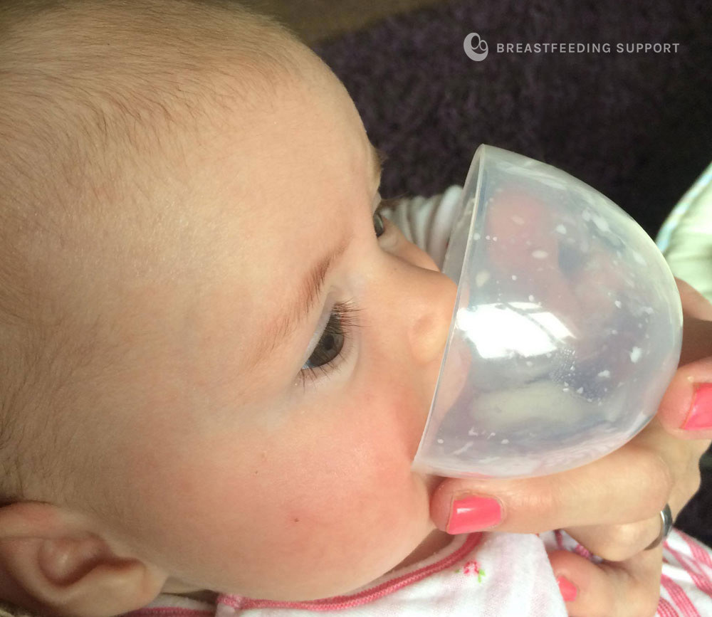 Baby drinking from a little cup