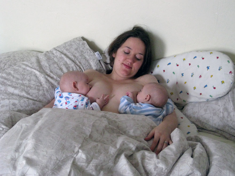 Mother breastfeeding twins in laid back position, twins on their tummies