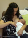 Mother breastfeeding her baby in straddle hold