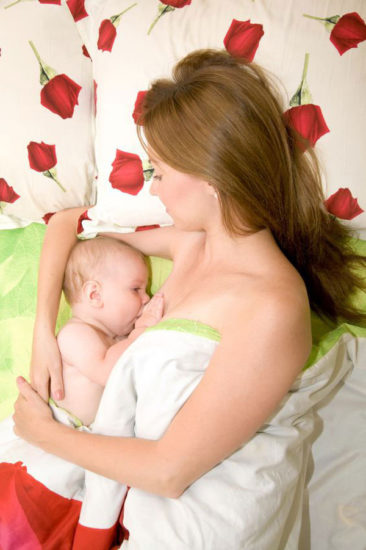 mother breastfeeding baby in bed