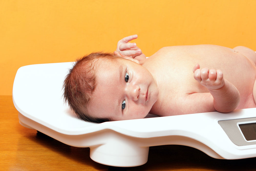 Close up of a baby on baby weighing scales