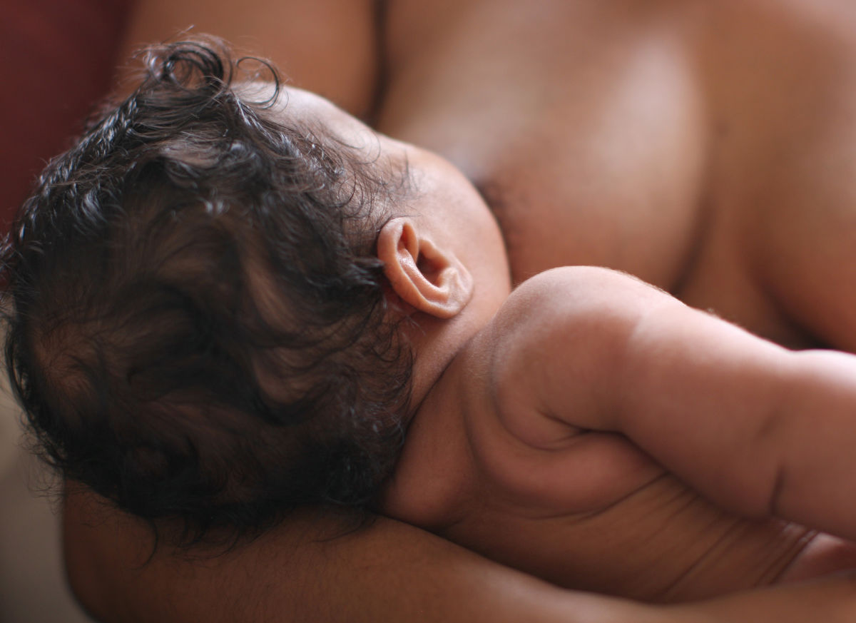 baby held skin to skin, view of the back of baby's head