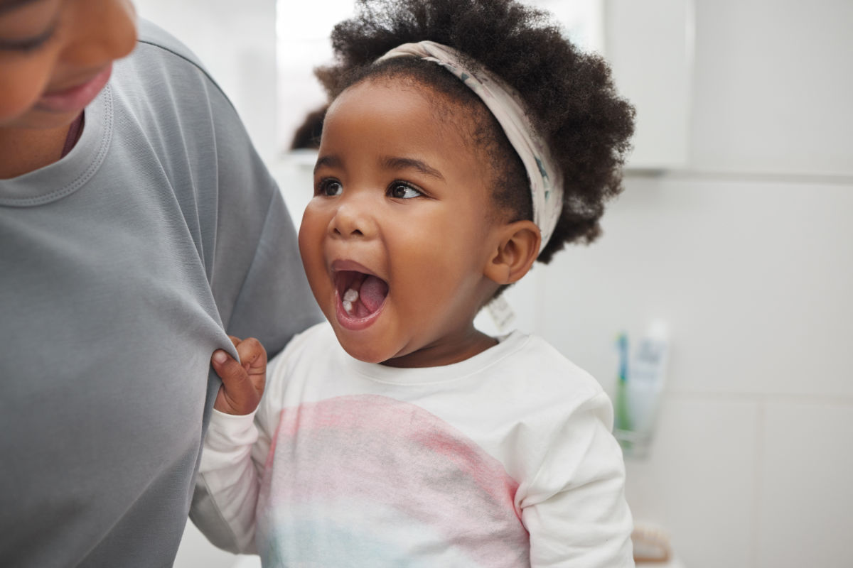 little girl showing her mom her first molar