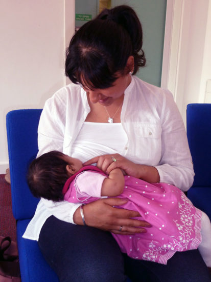baby breastfeeds in a cradle hold