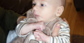 Underweight baby with clenched fists and frown