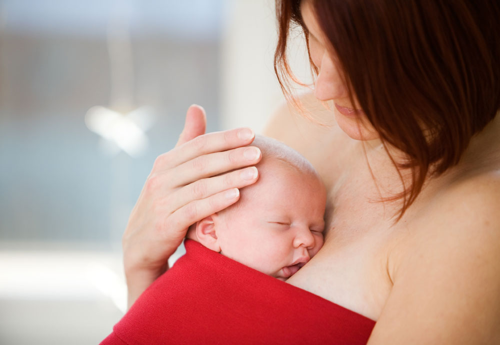 baby held on mother's chest