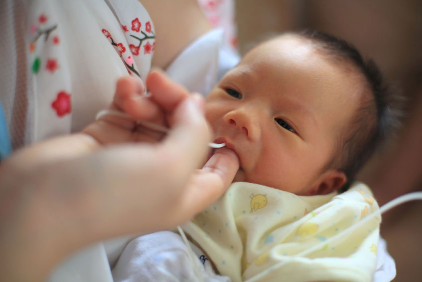 A young baby finger feeding